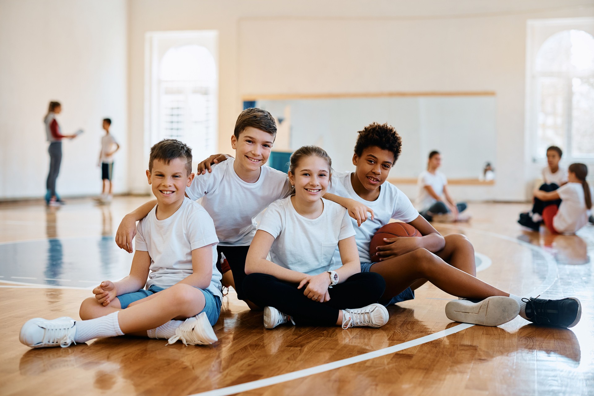 Multiracial group of happy kids on physical education class looking at camera.